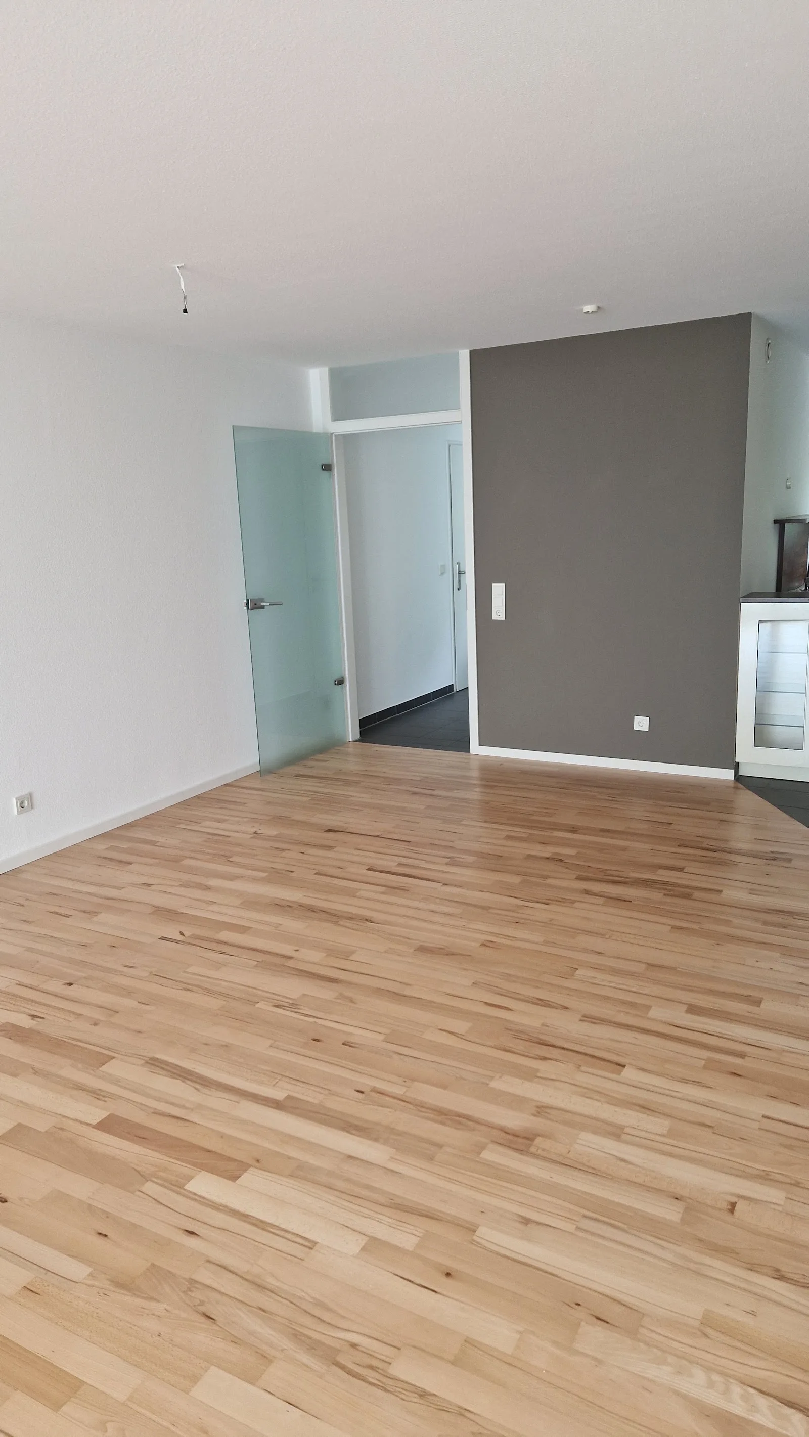 Leerer Wohnraum mit frisch verlegtem hellem Parkett