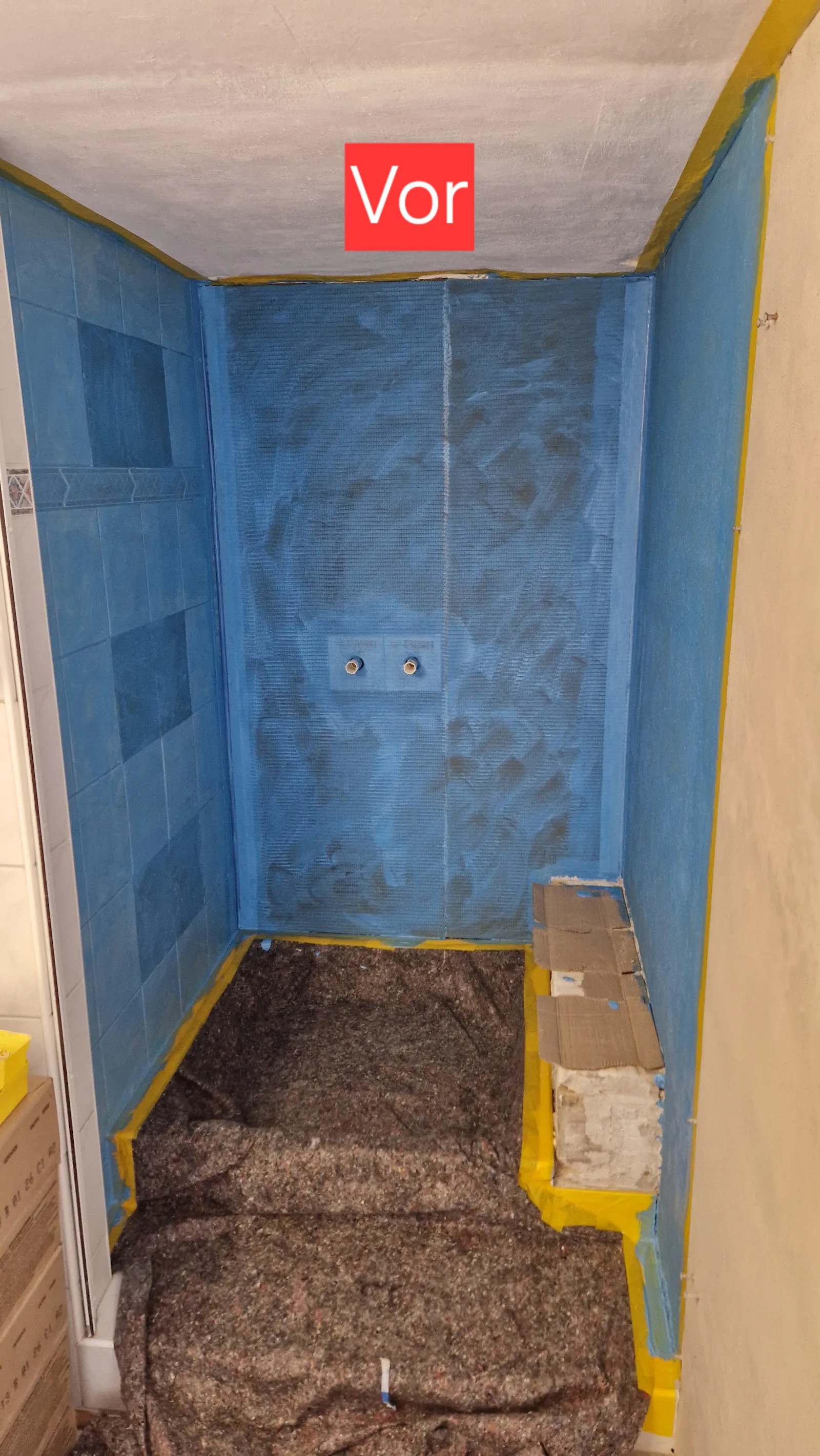 Duschnische mit blauer Dichtfolie, vom Betrieb mit einem roten Vor-Etikett markiert