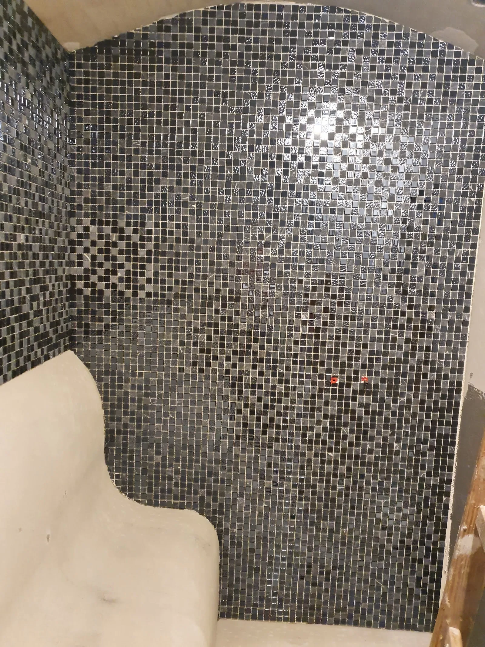 Dunkle Mosaik-Duschnische mit geschwungener Sitzbank